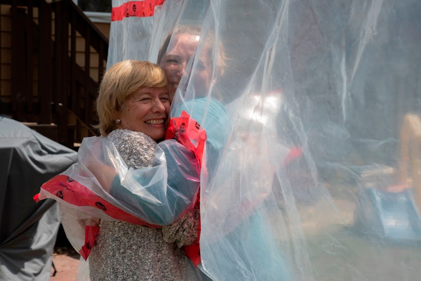 A socially distanced hug through plastic barriers is one way people are fulfilling the need to get t...