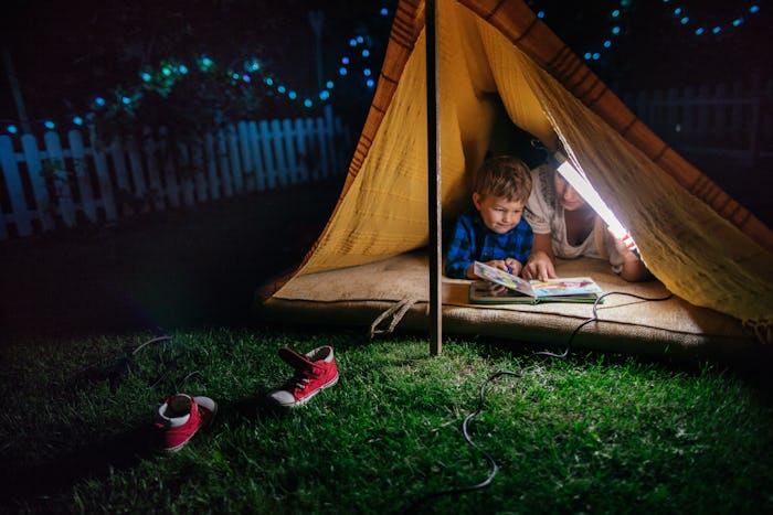 mom and boy camping in backyard tent