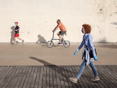 Cartoonish photo of random people on the street walking, running, and riding a bicycle 