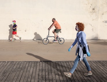 Cartoonish photo of random people on the street walking, running, and riding a bicycle 
