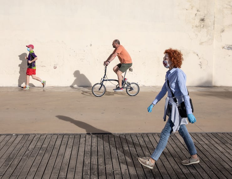 Cartoonish photo of random people on the street walking, running, and riding a bicycle