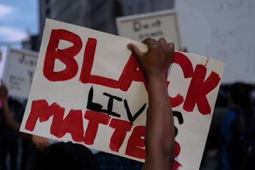 A person holds a Black Lives Matter sign. These are organizations to donate to & find mental health ...