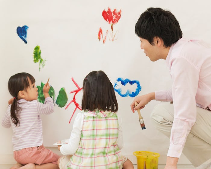 family painting mural on wall