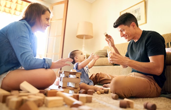 parents playing with baby on floor