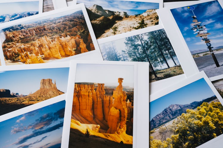 A bunch of Polaroid pictures from a trip are laid out on a table.