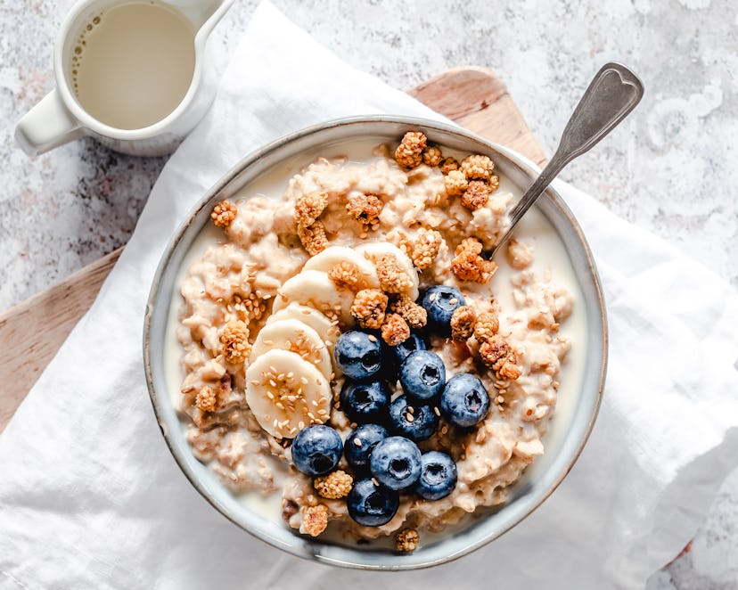 A bowl of oats with banana slices and blueberries