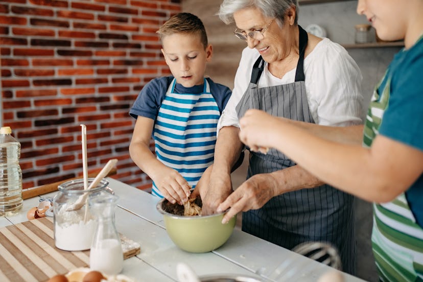 A grandmother babysitting her grandsons and spending time teaching them to bake