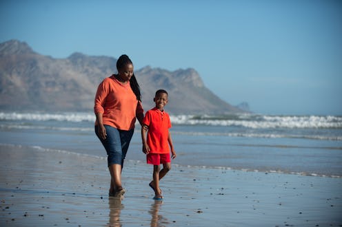 A grandmother babysitting her granddaughter walking down the beach together