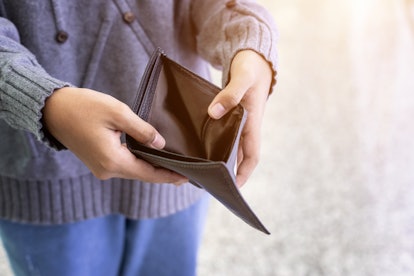 A woman holding her empty black wallet open