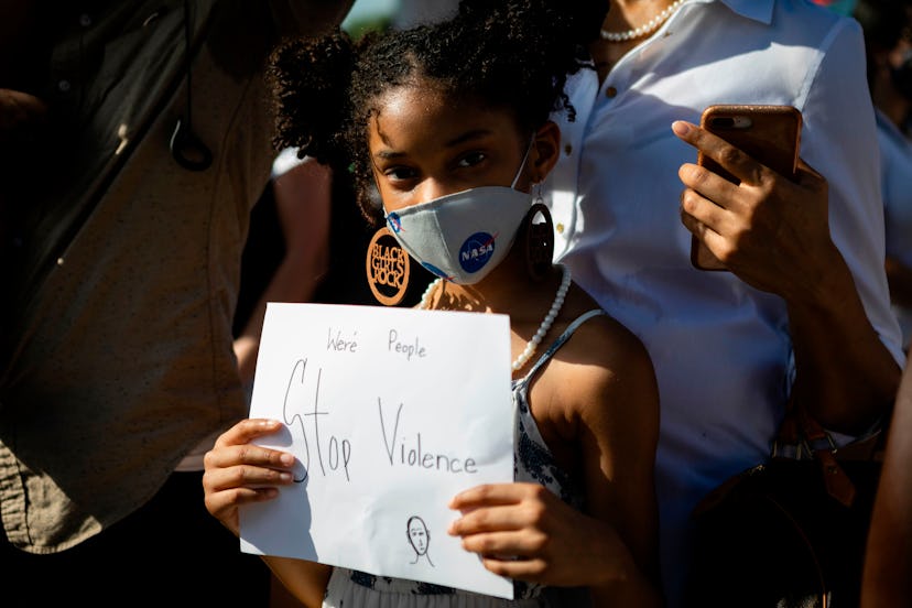 A young girl in a mask calls for a stop to violence 