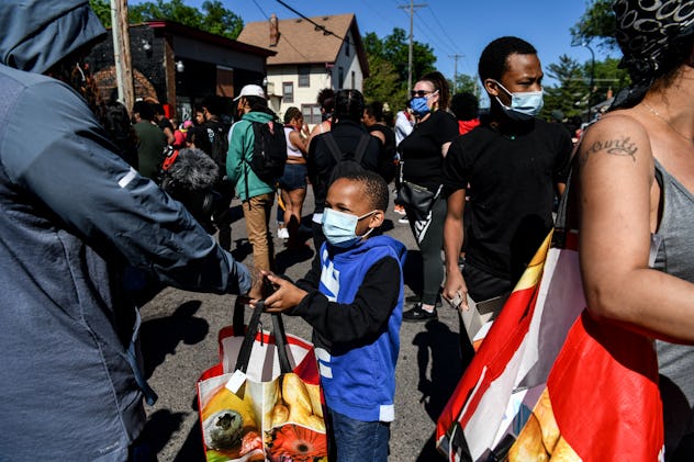A young boy distributes food and water to protestors