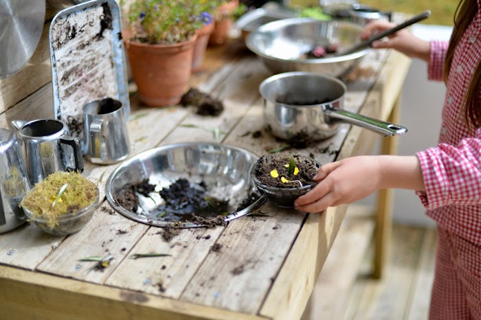 girl playing in mud kitchen