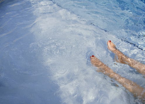 A woman lies in a pool. Does Hot Weather Make You Lazy? An expert explains the scientific link.