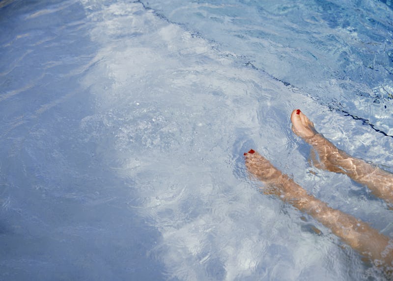 A woman lies in a pool. Does Hot Weather Make You Lazy? An expert explains the scientific link.