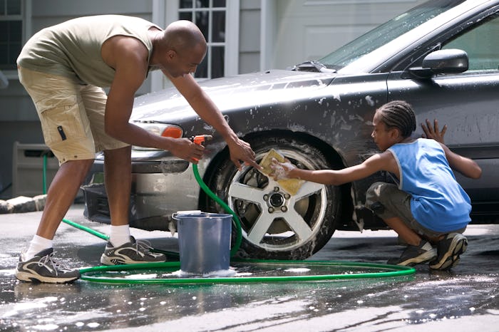 black dad and son washing car