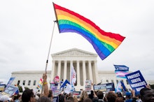 A group of LGBTQ protesters waving the LGBTQ flag in front of the US Capitol