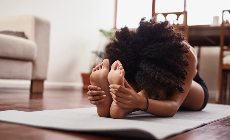 A woman stretches. This list details 24 people in the fitness industry to follow on instagram doing ...