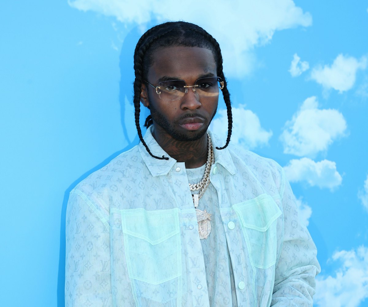 Pop Smoke in an all blue layered outfit standing infront of a sky-blue background with simple white ...