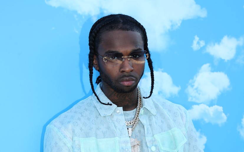 Pop Smoke in an all blue layered outfit standing infront of a sky-blue background with simple white ...