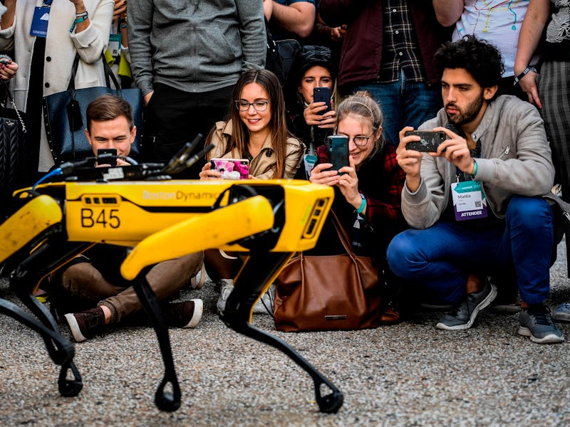 People taking photos of a yellow Boston Dynamics' Robotic Dog