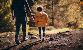 A dad and a kid in a walk in the nature staying away from ticks