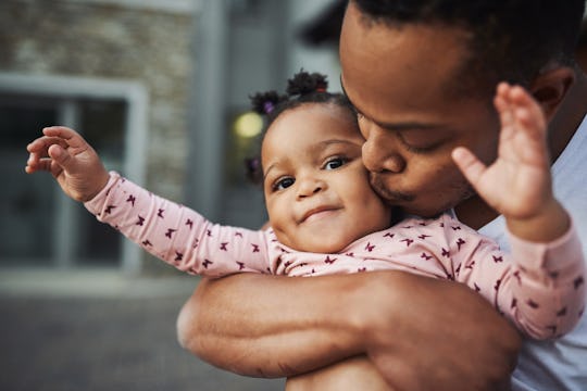 black dad hugging baby girl