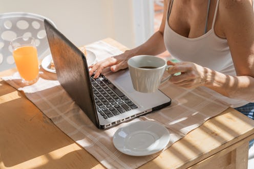 A woman deletes old facebook posts while drinking a coffee