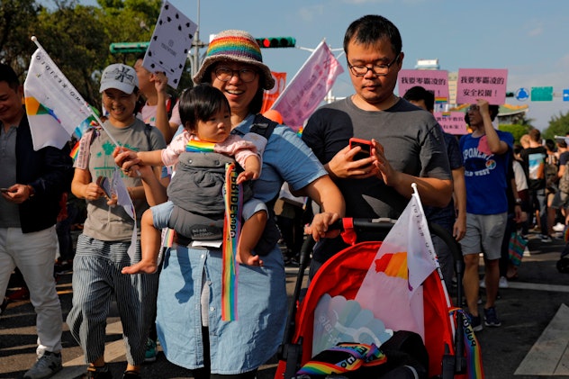 A family marches together at a Pride celebration 