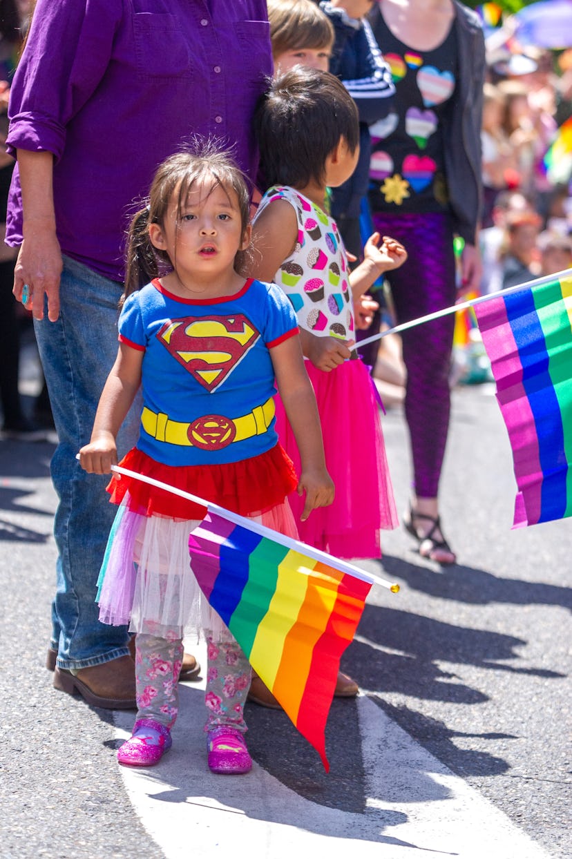  A young girl holds a rainbow flag