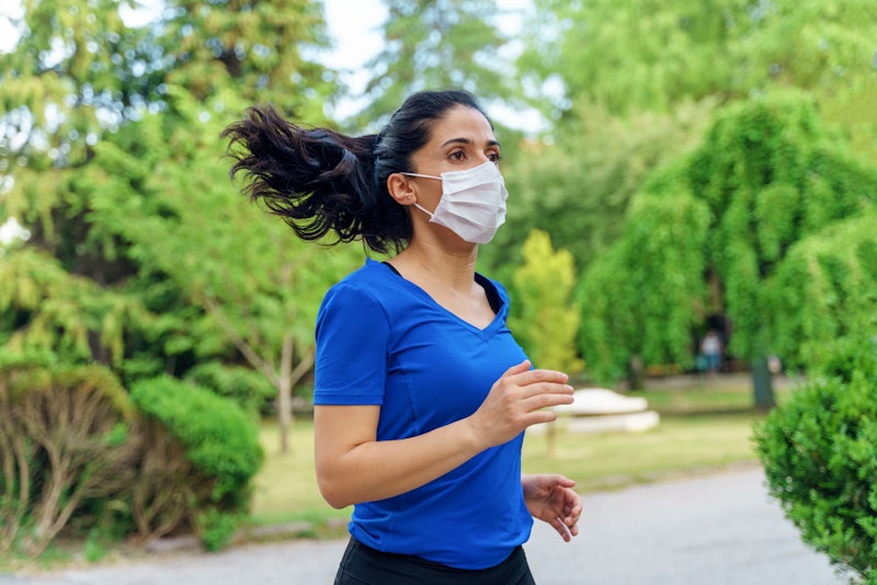 A person in a lblue v-neck wears a mask while running in a park. If you've started working out durin...