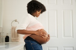 pregnant woman in bathroom holding her bump