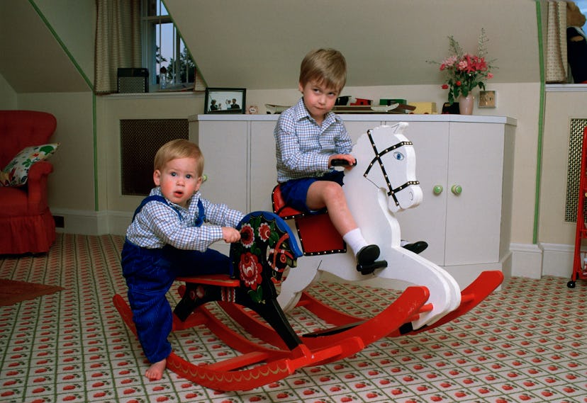Prince Harry rocks on a rocking horse in overalls