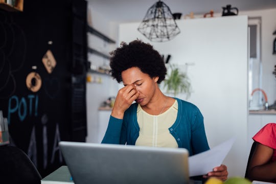 tired mom sitting at computer in kitchen