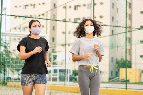 Two people run together outside while wearing masks. Even when your gym is closed, it is indeed poss...