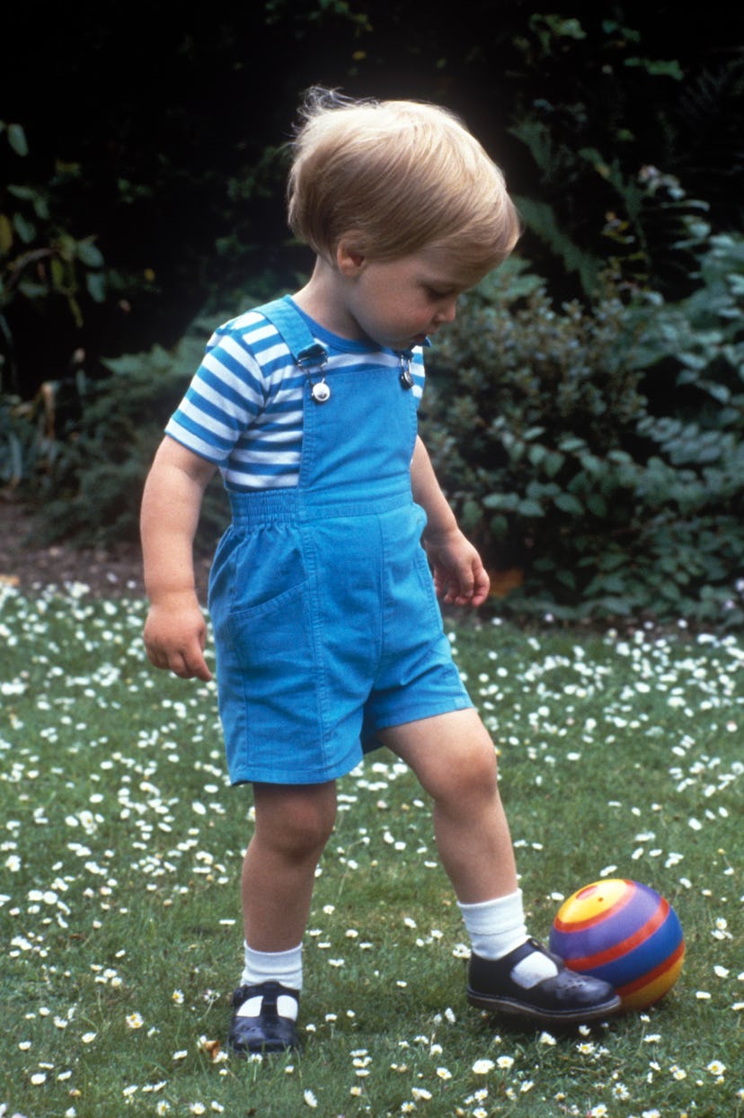 Prince William kicks a ball in his overalls