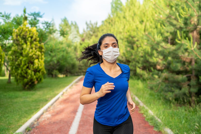 A person wearing a blue tee and a mask runs on an outdoor track. Especially when you're stressed out...