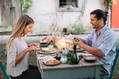 A young couple enjoys brunch at a decorated table in their backyard.
