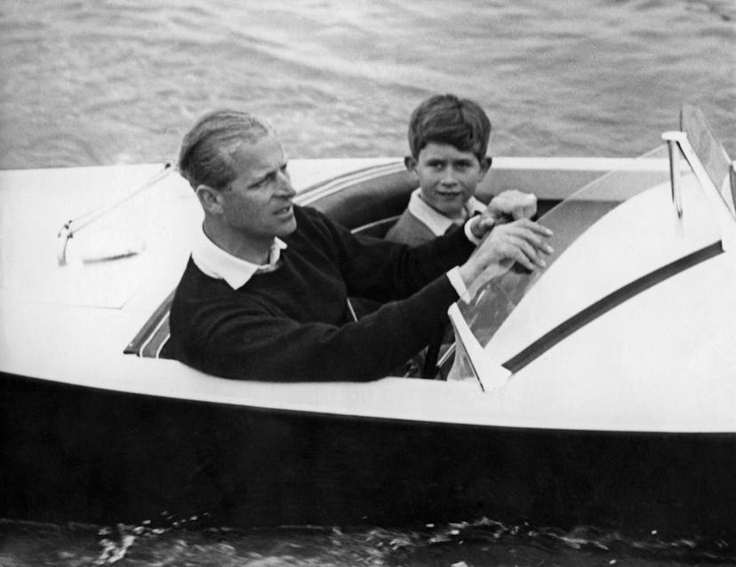 Prince Philip drives his son Prince Charles in a boat.