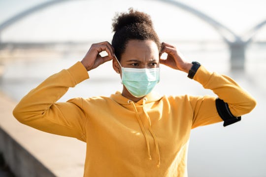 woman putting on face mask