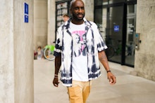 Virgil Abloh in a white black shirt, white t-shirt and beige pants