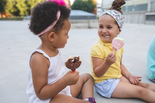 black and white toddler girls eating ice cream at park