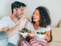A young couple laughs and eats salads using Tik Tok salad recipes like the Hot Girl Summer salad.