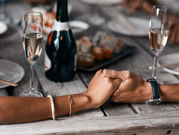 A young couple holds hands while tasting different champagnes.