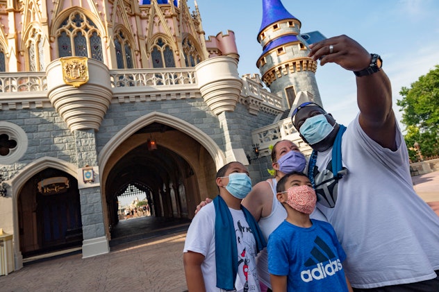 Family poses for a selfie outside Cinderella's Castle in the Magic Kingdom.