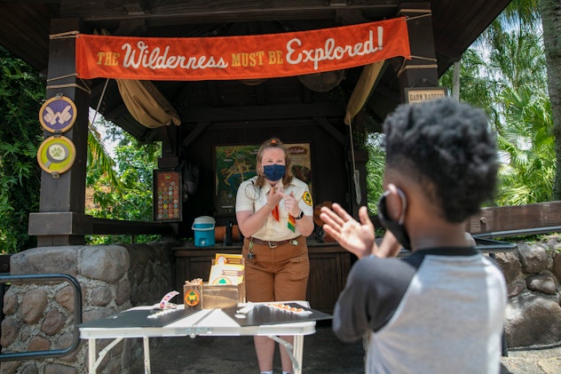 A cast member offers a young guest some hand sanitizer.
