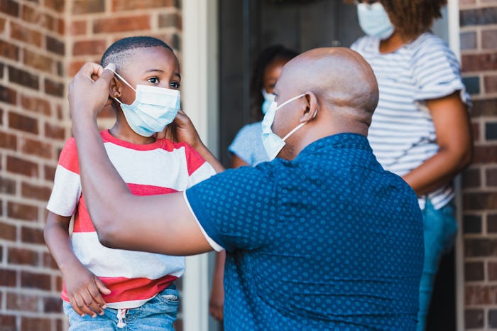 dad putting face mask on little boy