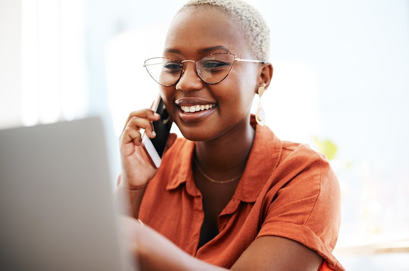 A black woman doing a background check on a possible dermatologist on her phone and laptop