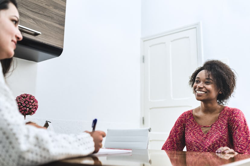 A black woman at an appointment with a white dermatologist