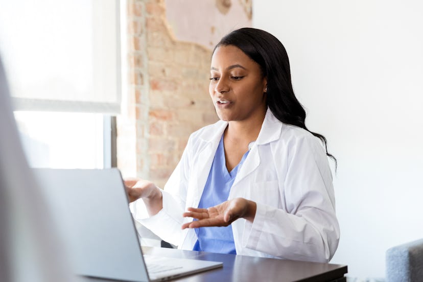 A dermatologist on a call on her laptop at work 