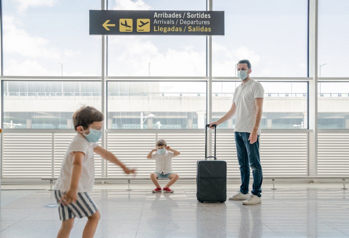 kids in airport wearing masks with dad